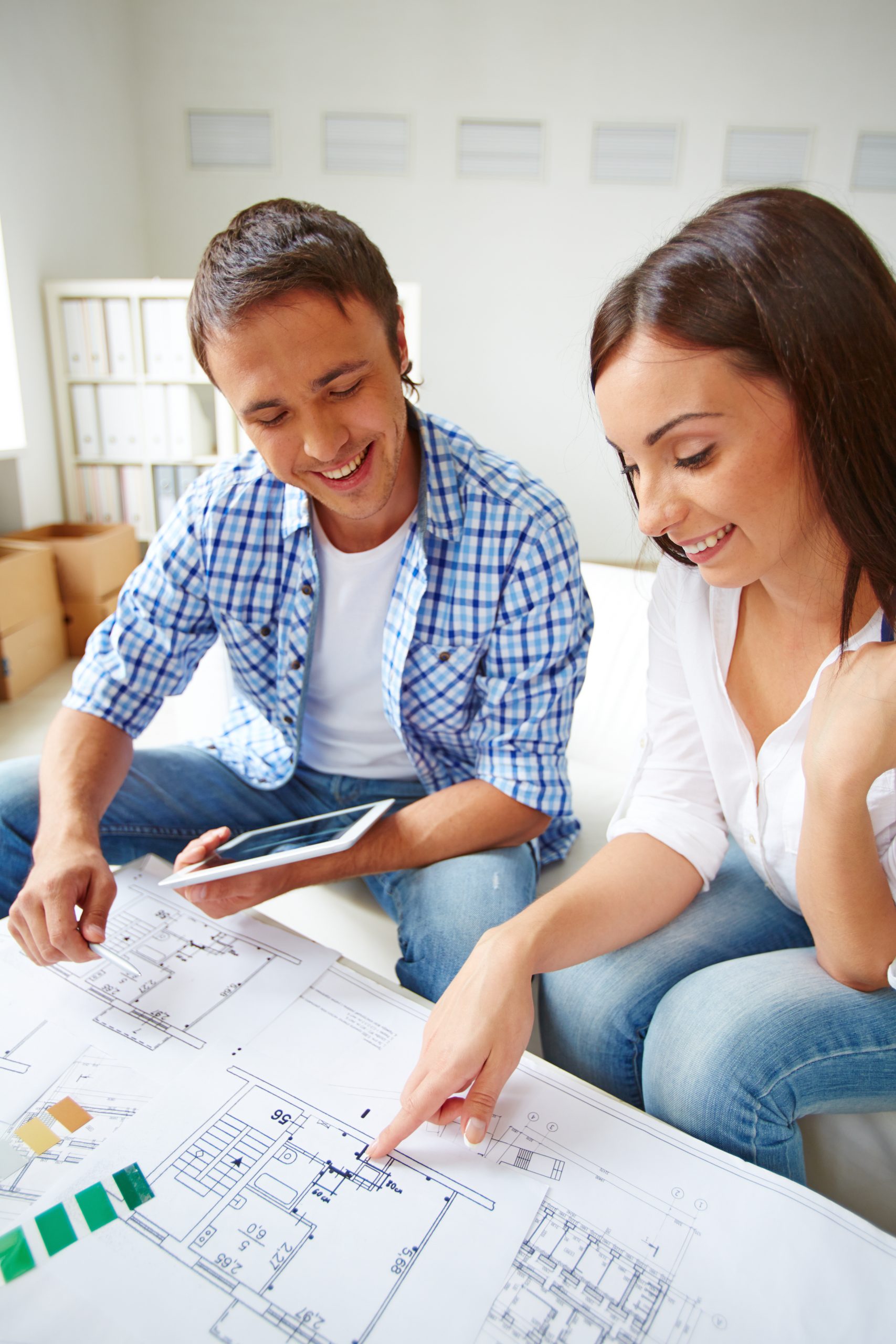Portrait of young couple discussing plan of new flat